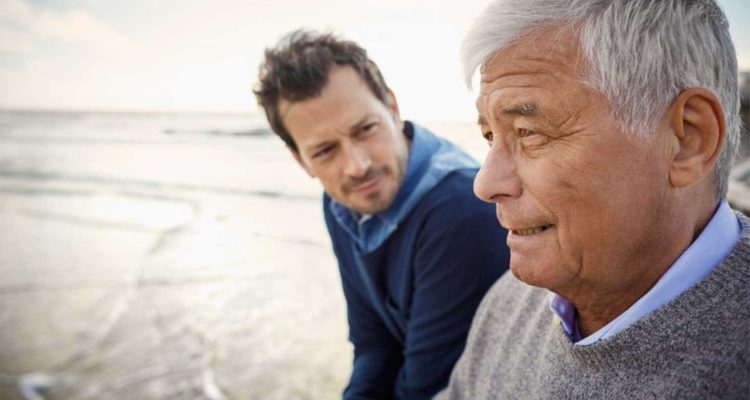 Father and son sitting on a wall talking